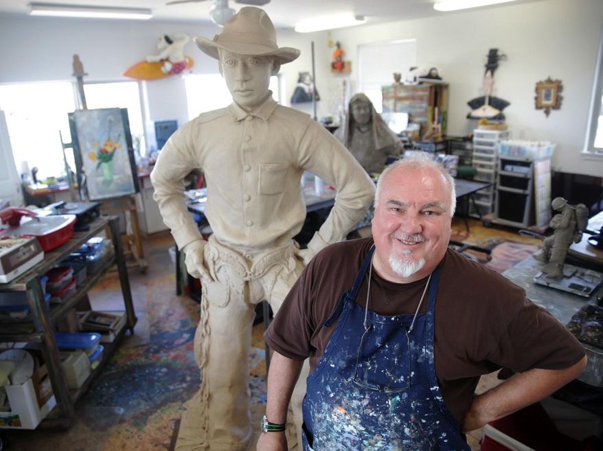 In this July 30, 2014 photo, artist Jerry Werner stands with his sculpture of George Fletcher in his studio in Tumalo, Ore. When Werner heard Pendleton, Ore. was looking for an artist to create a bronze sculpture of a rodeo cowboy for its downtown, he wasn’t interested. Then, he heard the story behind the particular cowboy - a story steeped in rodeo, racial injustice and the changing face of the American West. (AP Photo/The Bulletin, Meg Roussos)