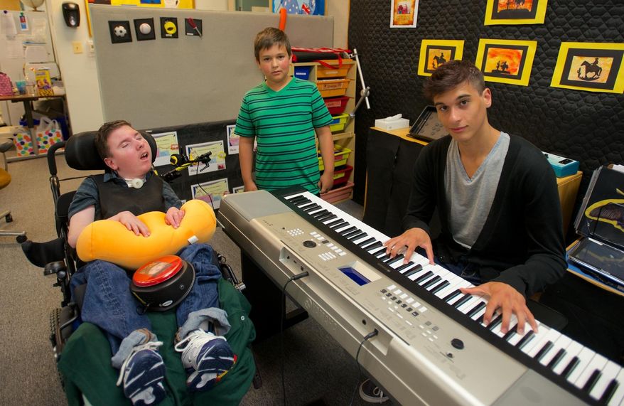 MEMBER EXCHANGE ADVANCE FOR SUNDAY, AUG. 10 - In this July 31, 2014 photo, 16-year-old Doug Anderson, right, poses with his twin brother Robbie, left, and younger brother Colton, rear, at Robbie's classroom at CREST school in Methuen, Mass., where Doug performed music for the special education students. (AP Photo/The Eagle-Tribune, Ryan Hutton)