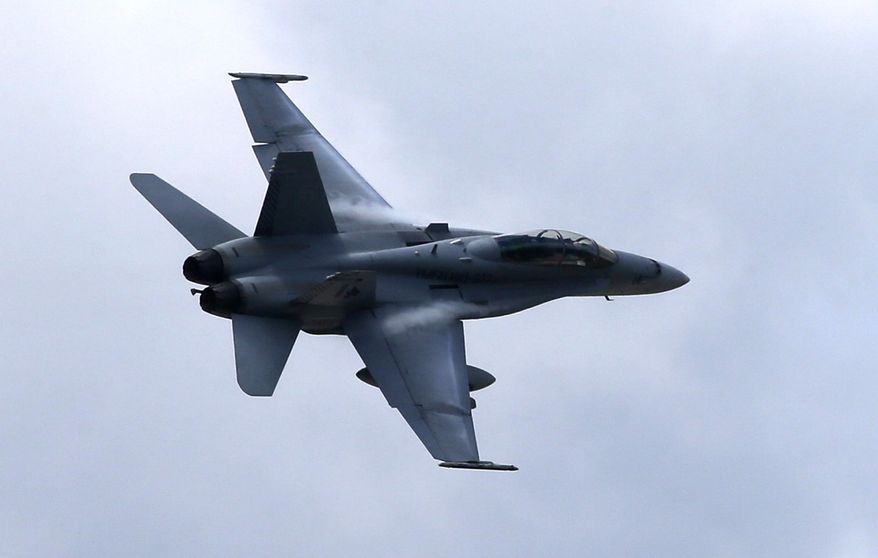 ** FILE ** In this April 12, 2013, file photo, a U.S. Marine F/A-18 Hornet jet flies low pass during Philippines-U.S. joint military exercise in northern Philippines. President Barack Obama authorized U.S. airstrikes in northern Iraq, Thursday, Aug. 7, 2014, warning they would be launched if needed to defend Americans from advancing Islamic militants and protect civilians under siege. Obama said American military planes already had carried out airdrops of humanitarian aid to tens of thousands of Iraqi religious minorities surrounded by militants and desperately in need of food and water. The Pentagon said the airdrops were performed by one C-17 and two C-130 cargo aircraft that together delivered a total of 72 bundles of food and water. They were escorted by two F/A-18 fighters. (AP Photo/Bullit Marquez)