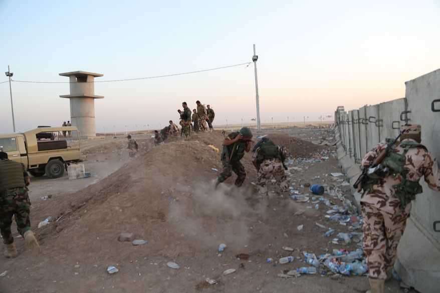 Kurdish Peshmerga fighters take cover during airstrikes targeting Islamic State militants near the Khazer checkpoint outside of the city of Irbil in northern Iraq, Friday, Aug. 8, 2014. Iraqi Air Force has been carrying out strikes against the militants, and for the first time on Friday, U.S. war planes have directly targeted the extremist Islamic State group, which controls large areas of Syria and Iraq. (AP Photo/Khalid Mohammed)