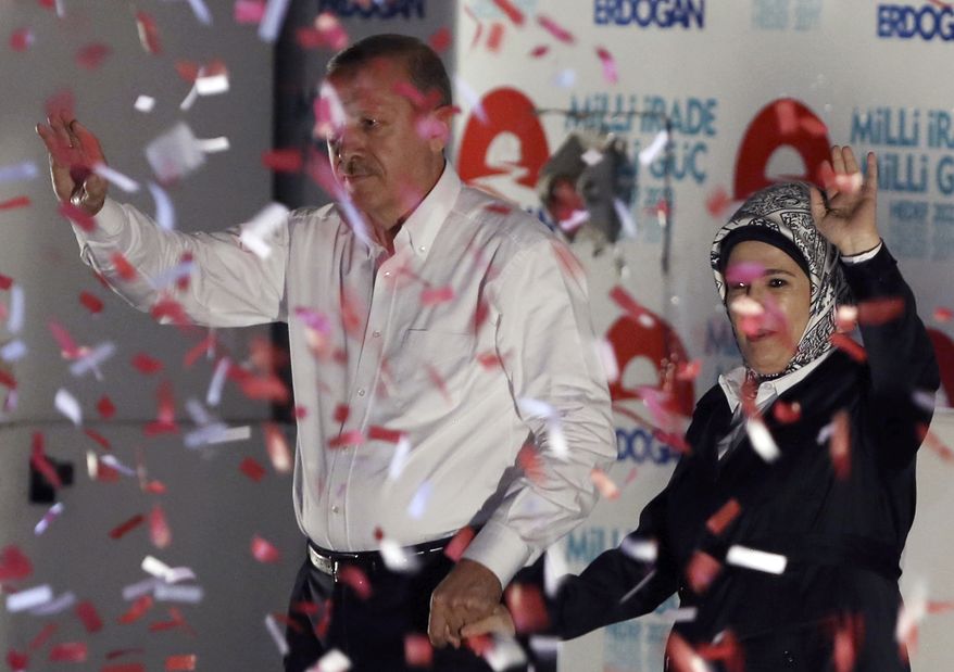 Turkish Prime Minister Recep Tayyip Erdogan and his wife Emine Erdogan wave to supporters after a rally in Ankara, Turkey, Friday, Aug. 8, 2014. Some 53 million Turks go the polls on Sunday to choose their 12th president in an election considered a turning point for the country of 76 million people, with Prime Minister Recep Tayyip Erdogan vying for the position he has pledged to transform from a symbolic role into a position of power. Ekmeleddin Ihsanoglu, the former chief of the Organization of Islamic Cooperation, and Kurdish politician Selahattin Demirtas are also running. (AP Photo/Burhan Ozbilici)
