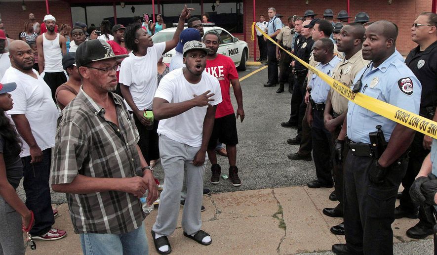 A crowd is stopped by police as they were trying to reach the scene where 18-year-old Michael Brown was fatally shot by police in Ferguson, Mo., near St. Louis on Saturday, Aug. 9, 2014. A spokesman with the St. Louis County Police Department confirmed a Ferguson police officer shot the man. The spokesman didn’t give the reason for the shooting, nor provide the officer’s name or race. (AP Photo/St. Louis Post-Dispatch, Huy Mach)