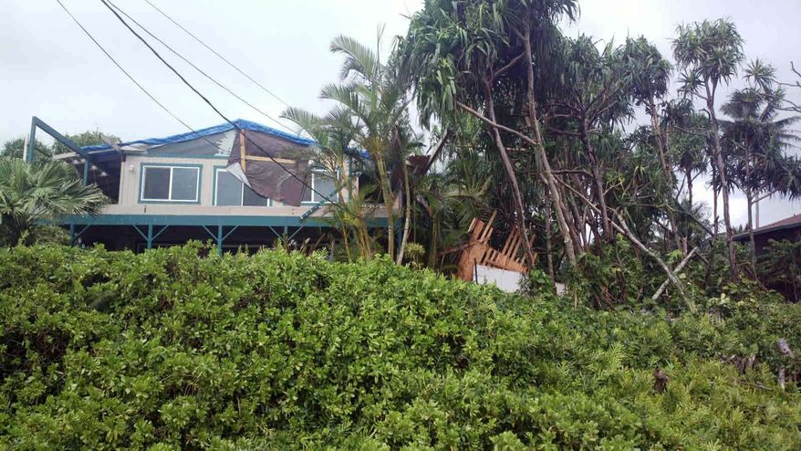 This photo provided by Andrew Fujimura shows the damage from Tropical Storm Iselle on a home in Puna, Hawaii, on Saturday, Aug. 9, 2014. Tropical Storm Iselle, knocked down trees, battered roofs and left the isolated area without electricity. (AP Photo/Courtesy Andrew Fujimura)