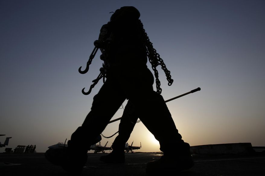 Sailors work at sunset on the flight deck of the U.S. Navy aircraft carrier USS George H.W. Bush on Sunday, Aug. 10, 2014 in the Persian Gulf. Aircrafts aboard the George H.W. Bush are flying missions over Iraq after U.S. President Barack Obama authorized airstrikes against Islamic militants and food drops for Iraqis trapped by the fighters. (AP Photo/Hasan Jamali)