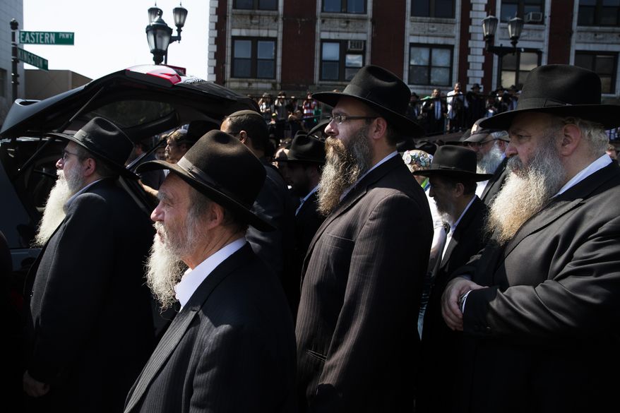 Mourners walk behind a hearse carrying the casket of Orthodox Rabbi Joseph Raksin, who was fatally shot Saturday while in Florida visiting relatives, Monday, Aug. 11, 2014, in the Brooklyn borough of New York. Police have said the death appeared to result from a robbery and not a hate crime, but they're still investigating. (AP Photo/John Minchillo)