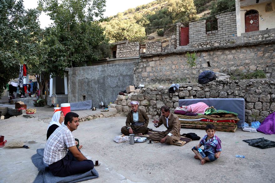 Displaced Iraqis from the Yazidi community settle near the holy Lalish temple in the Mountains of Shikhan near Dahuk, 260 miles (430 kilometers) northwest of Baghdad Monday, Aug. 11, 2014. President Barack Obama authorized the airstrikes to protect U.S. interests and personnel in the region, including at facilities in Irbil, as well as Yazidi refugees fleeing militants. (AP Photo/ Khalid Mohammed)