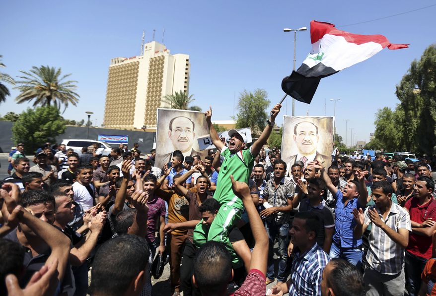 Iraqis chant pro-government slogans and wave national flags in a show of support for embattled Prime Minister Nouri al-Maliki during a demonstration in Baghdad, Iraq, Monday, Aug. 11, 2014. Al-Maliki is taking his struggle to keep his job to the courts after announcing he will file a legal complaint on Monday against the country's newly elected president. President Barack Obama warned Americans on Saturday that the new campaign to bring security in Iraq requires military and political changes and "is going to be a long-term project." (AP Photo/ Hadi Mizban)