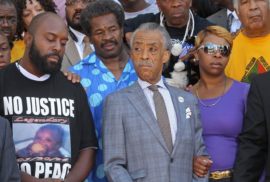 Michael Brown Jr.'s parents, Michael Brown Sr., left, and Lesley McSpadden, right, stand next to the Rev. Al Sharpton on Tuesday, Aug. 12, 2014, in St. Louis. Sharpton pressed police Tuesday to release the name of the officer who fatally shot Brown Jr., an unarmed teenager in suburban St. Louis, but he also pleaded for calm after two nights of violent protests. (AP Photo/St. Louis Post-Dispatch, J.B. Forbes)