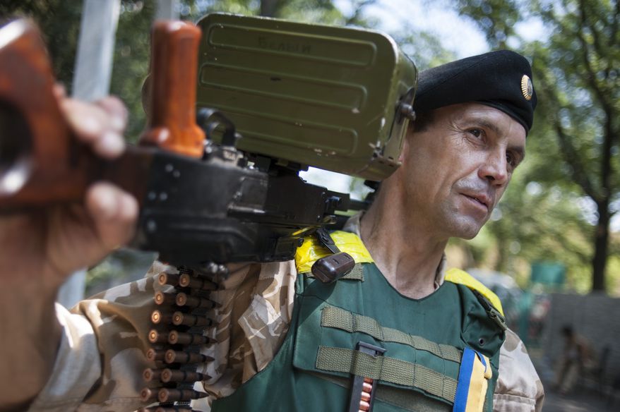 A Ukrainian government soldier from the "Donbass" battalion guards a position in the village of Mariinka, near Donetsk, eastern Ukraine, Tuesday, Aug. 12, 2014. Kiev and the West have repeatedly opposed any Russian humanitarian aid mission to eastern Ukraine, fearing that such a move could preface an intervention by Moscow. Throughout the conflict, Ukraine and the West have accused Russia of aiding the rebels with arms and expertise, a charge that the Kremlin has denied. (AP Photo/Evgeniy Maloletka)