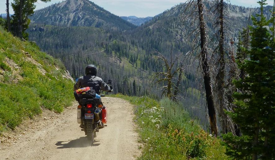 This photo taken on July 20, 2014, shows a motorcycle rider on a backcountry road heading to Graham, about 45 miles northeast of Idaho City, Idaho. Getting to Graham means going through a long gravel road and over an 8,300-foot pass before descending into the headwaters of the North Fork of the Boise River.  (AP Photo/The Idaho Statesman, Roger Phillips)  LOCAL TELEVISION OUT (KTVB 7); MANDATORY CREDIT