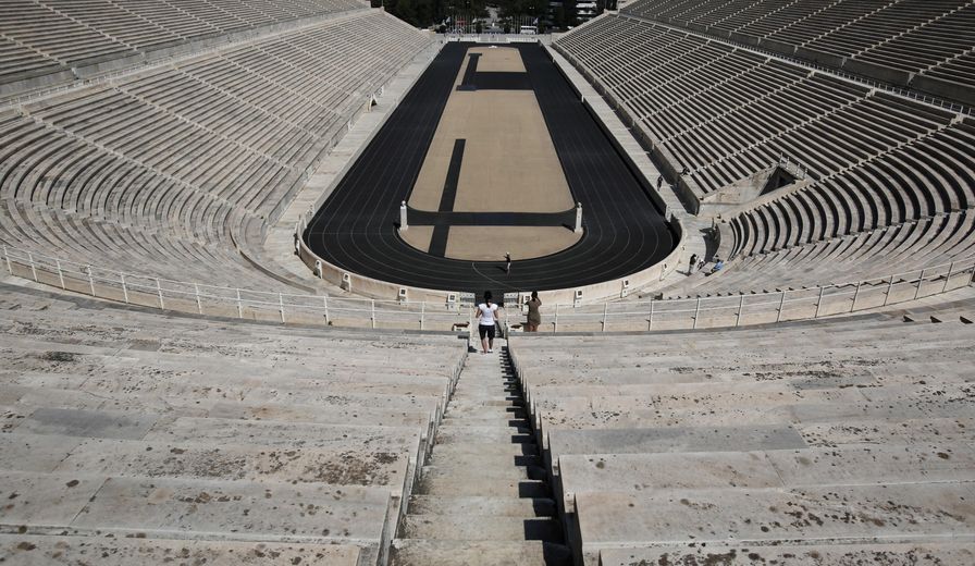 In this Monday, Aug. 11, 2014 photo tourists visit Panathenaic stadium in Athens. The old Olympic Stadium of Athens, a marble reconstruction of the city’s ancient stadium built for the first modern Olympics held in Athens is open to ticket-paying visitors who can also visit a small Olympic museum on the site. (AP Photo/Petros Giannakouris)
