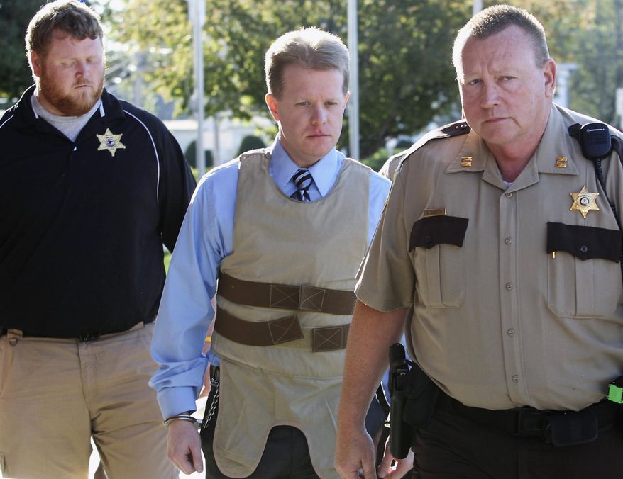 FILE - In this April 12, 2011 file photo, murder suspect Christopher Coleman, center, is escorted to the Perry County Courthouse in Pinckneyville, Ill., during his trial. On Tuesday, Aug. 12, 2014, an Illinois appeals court reinstated the wrongful-death lawsuit claiming Joyce Meyer Ministries should have done more to prevent Coleman from killing his family. Coleman strangled his wife and two sons inside the family's Columbia home in 2009. It was filed on behalf of the family of Sheri Coleman, Christopher Coleman's wife. (AP Photo/The Belleville News-Democrat, Derik Holtmann, File)