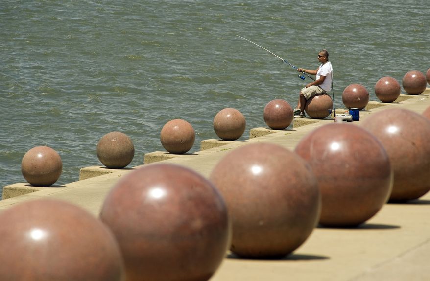 Jonathon LeGate fishes in the Ohio River at Dress Plaza in downtown Evansville, Ind.,on Tuesday, Aug. 12, 2014. "This is the first time I've fished down here since I was a kid," LeGate said. (AP Photo/The Courier & Press, Kevin Swank)