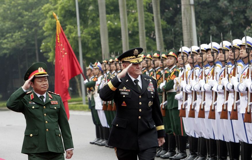 U.S. Chairman of the Joint Chiefs of Staff, Gen. Martin Dempsey, right, and Vietnamese Chief of General Staff of the Army, Lt. Gen. Do Ba Ty, left, review an honor guard before their talks in Hanoi, Vietnam on Thursday Aug. 14, 2014. Dempsey will hold talks with Vietnamese defense officials Wednesday on a visit that aims to boost military ties between the two former foes. (AP Photo/Tran Van Minh)