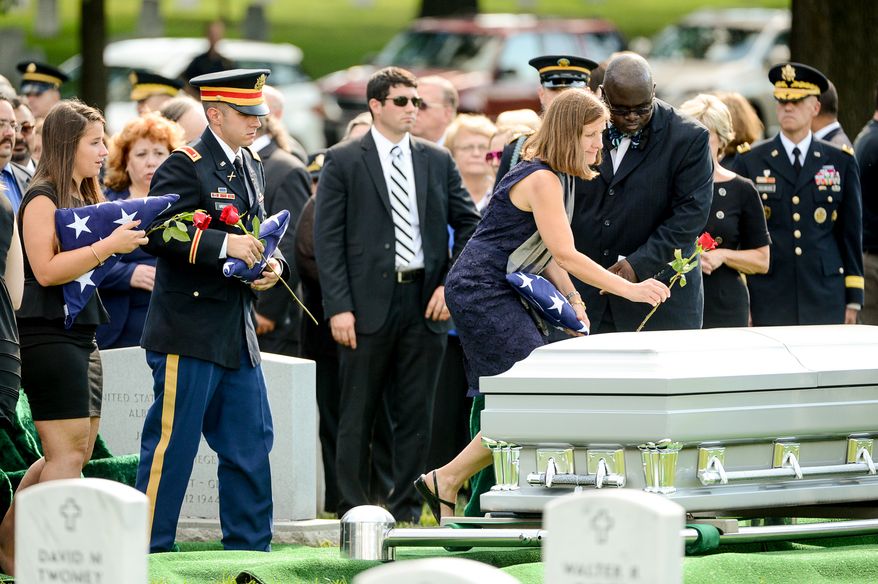 The children of Army Maj. Gen. Harold J. Greene, his daughter Amelia Greene, left, and his son Army 1st Lt. Matthew Greene, second from left, watches as Dr. Susan Myers, the wife of Army Maj. Gen. Harold J. Greene puts a rose on his coffin during his funeral service at Section 60 at Arlington National Cemetery, Arlington, Va., Thursday, August 14, 2014. Greene was killed in Afghanistan while at the national military academy in Kabul. He was the highest-ranking U.S. Army officer killed in combat since the Vietnam War. (Andrew Harnik/The Washington Times)