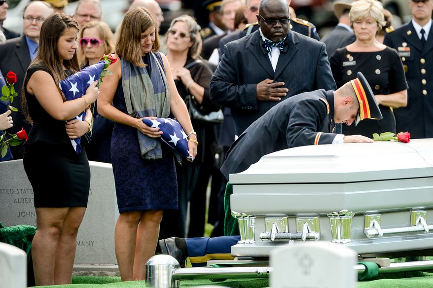The family of Army Maj. Gen. Harold J. Greene, from left, daughter Amelia Greene, wife Dr. Susan Myers, and son Army 1st Lt. Matthew Greene, each take turns placing a rose on his coffin during his funeral service at Section 60 at Arlington National Cemetery, Arlington, Va., Thursday, August 14, 2014. Greene was killed in Afghanistan while at the national military academy in Kabul. He was the highest-ranking U.S. Army officer killed in combat since the Vietnam War. (Andrew Harnik/The Washington Times)