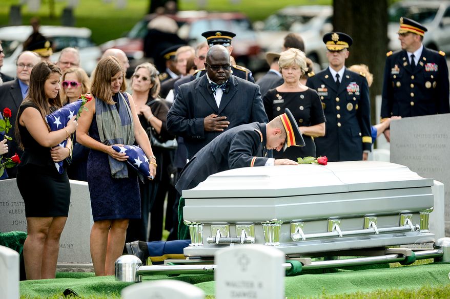 The family of Army Maj. Gen. Harold J. Greene, from left, daughter Amelia Greene, wife Dr. Susan Myers, and son Army 1st Lt. Matthew Greene, each take turns placing a rose on his coffin during his funeral service at Section 60 at Arlington National Cemetery, Arlington, Va., Thursday, August 14, 2014. Greene was killed in Afghanistan while at the national military academy in Kabul. He was the highest-ranking U.S. Army officer killed in combat since the Vietnam War. (Andrew Harnik/The Washington Times)