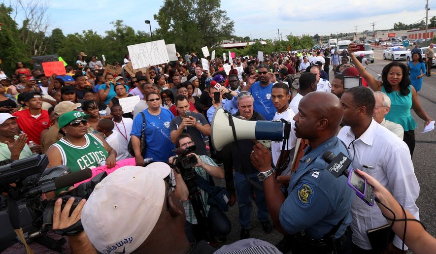 Missouri State Highway Patrol Capt. Ronald Johnson addresses the crowd of protesters, asking them to stay on the sidewalk and not block traffic Thursday, Aug. 14, 2014, in Ferguson, Mo. The Missouri Highway Patrol took control of a St. Louis suburb Thursday, stripping local police of their law-enforcement authority after four days of clashes between officers in riot gear and furious crowds protesting the death of an unarmed black teen shot by an officer. (AP Photo/St. Louis Post-Dispatch, David Carson)