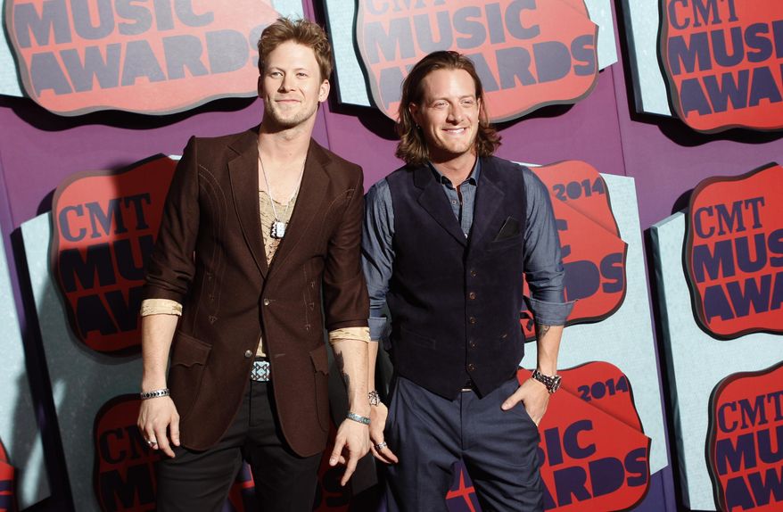 FILE - This June 4, 2014 file photo shows Brian Kelley, left, and Tyler Hubbard of the musical group Florida Georgia Line arrive at the CMT Music Awards at Bridgestone Arena on in Nashville, Tenn. The duo will release their latest album, "Anything Goes," out Oct. 14. (Photo by Wade Payne/Invision/AP, File)
