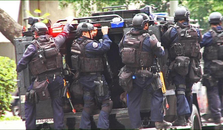 In this July 6, 2013 still frame from a video produced by the Los Angeles Police Department, officers ride on an armored medical rescue vehicle in a drill simulating a terrorist attack in downtown Los Angeles. After spending a decade sending military equipment to civilian police departments across the United States, Washington is reconsidering the idea in light of the violence in Ferguson, Mo., amid images of heavily-armed police, snipers trained on protesters and tear gas plumes. One night after the violence that accompanied the presence of military-style equipment in Ferguson, the crowd calmed considerably when a police captain walked through the crowd, unprotected, in a gesture of reconciliation. The contrast added to the perception that the tanks and tear gas had done more harm than good. (AP Photo/Los Angeles Police Department)