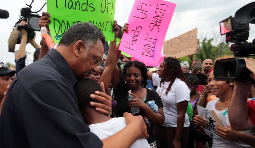 ** FILE ** Civil rights leader Rev. Jesse Jackson hugs Jakailin Johnson, 11, as he greets a group of protestors on Friday, Aug. 15, 2014, who gathered to demonstrate for justice in the Michael Brown shooting at the burned QuikTrip in Ferguson. (AP Photo/St. Louis Post-Dispatch, Laurie Skrivan)