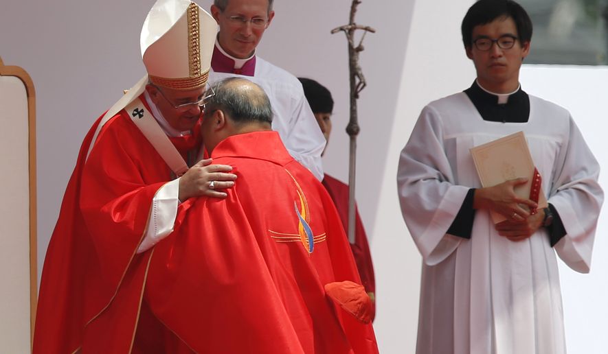 Pope Francis, left, hugs with South Korean cardinal Andrew Yeom Soo-Jung during the holy mass in front of Gwanghwamun Gate in Seoul on Saturday. Pope Francis beatified 124 Korean martyrs on Saturday. (AP Photo/Issei Kato, Pool)