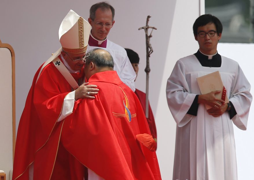 Pope Francis, left, hugs with South Korean cardinal Andrew Yeom Soo-Jung during the holy mass in front of Gwanghwamun Gate in Seoul on Saturday. Pope Francis beatified 124 Korean martyrs on Saturday. (AP Photo/Issei Kato, Pool)