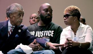 Rev. Al Sharpton speaks with parents of Michael Brown, Michael Brown Sr. and Lesley McSpadden during a rally at Greater Grace Church, Sunday, Aug. 17, 2014, for their son who was killed by police last Saturday in Ferguson, Mo. Brown&#x27;s shooting in the middle of a street, following a suspected robbery of a box of cigars from a nearby market, has sparked a week of protests, riots and looting in the St. Louis suburb. (AP Photo/Charlie Riedel)