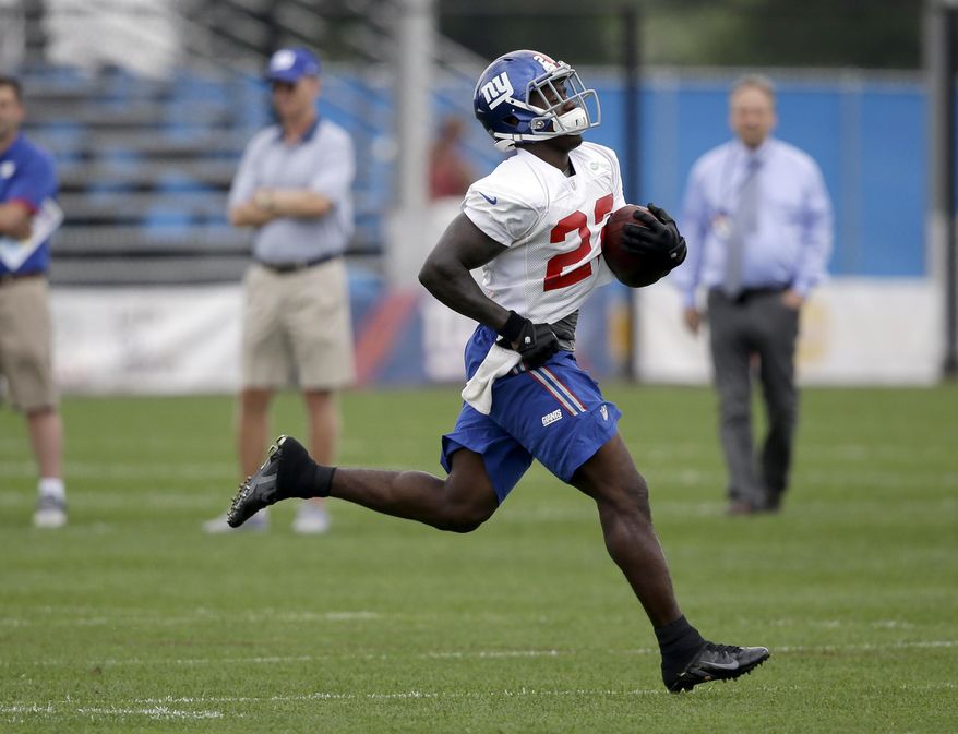 FILE - In this July 24, 2014, file photo, New York Giants running back David Wilson runs the ball during NFL football camp in East Rutherford, N.J. Two weeks after ending his NFL career due to a neck injury, former Giants' Wilson is turning to track and field. The 23-year-old Wilson, who competed in the triple jump during high school and at Virginia Tech, intends to train in the event with an eye on making the United States team for the 2016 Rio Olympics. (AP Photo/Seth Wenig, File)