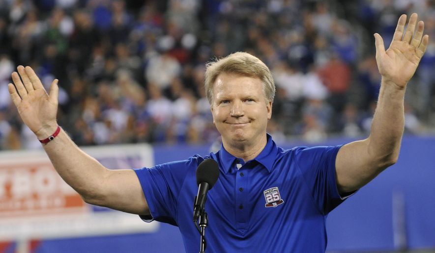 Former New York Giants quarterback Phil Simms waves to the fans during halftime of an NFL football game against the St. Louis Rams Monday, Sept. 19, 2011, in East Rutherford, N.J. (AP Photo/Bill Kostroun)