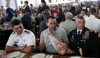 United States men&#39;s national basketball team head coach Mike Krzyzewski, center, dines with Lt. Gen. Robert Caslen Jr., superintendent of the U.S. Military Academy, right, at Washington Hall on Monday, Aug. 18, 2014, in West Point, N.Y. The team was at the academy for a practice session. (AP Photo/Mike Groll)