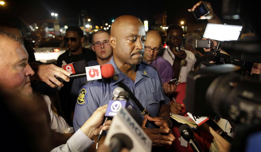 Capt. Ron Johnson of the Missouri Highway Patrol is surrounded by media after meeting with protesters Monday, Aug. 18, 2014, in Ferguson, Mo. The Aug. 9 shooting of Michael Brown by a police officer has touched off rancorous protests in Ferguson, a St. Louis suburb where police have used riot gear and tear gas. (AP Photo/Jeff Roberson)