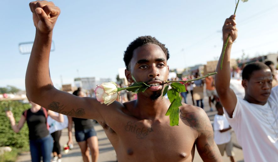 Protesters march on Tuesday for 18-year-old Michael Brown, who was killed by police Aug. 9 in Ferguson, Missouri. Ferguson&#x27;s leaders urged residents Tuesday to stay home after dark to &quot;allow peace to settle in&quot; and pledged several actions to reconnect with the predominantly black community in the St. Louis suburb. (Associated Press)