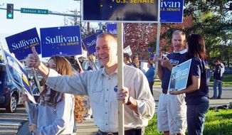 Dan Sullivan, candidate for the Republican candidate for election to the U.S. Senate, waves signs along a busy street on the morning of Alaska&#39;s primary election Tuesday, Aug. 19, 2014, in Anchorage, Alaska. (AP Photo/Becky Bohrer)