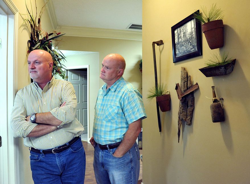 Greg and Clay Lyons, left, have a display from Pine Top in their accounting firm in Macclenny, Fla. on Thursday, Aug. 14, 2014. (AP Photo/Florida Times-Union, Bruce Lipsky)