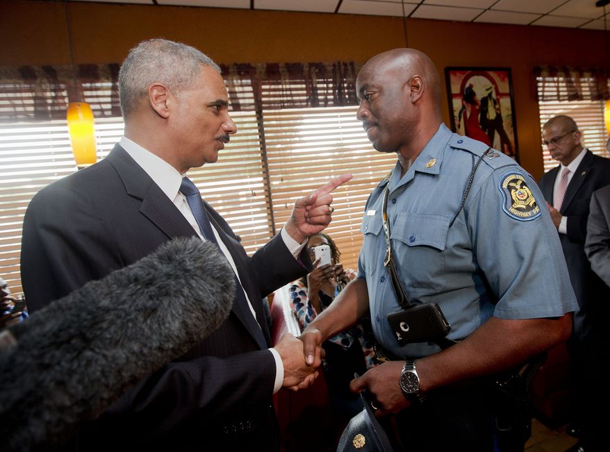 Attorney General Eric Holder talks with Capt. Ron Johnson of the Missouri State Highway Patrol at Drake&#x27;s Place Restaurant, Wednesday, Aug. 20, 2014, in Florrissant, Mo. Holder arrived in Missouri on Wednesday, as a small group of protesters gathered outside the building where a grand jury could begin hearing evidence to determine whether a Ferguson police officer who shot 18-year-old Michael Brown should be charged in his death. (AP Photo/Pablo Martinez Monsivais, Pool)