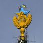 A worker takes a selfie before removing a yellow and blue Ukrainian flag attached by protesters atop Stalin-era skyscraper  in Moscow, Russia, Wednesday, Aug. 20, 2014. Protesters on Wednesday scaled one of Moscow&#x27;s famed Stalin-era skyscrapers and painted the Soviet star on its spire in the national colors of Ukraine. The dangerous prank, which set Russian social networking sites abuzz, drew a harsh response from the police.(AP Photo/Ilya Varlamov)