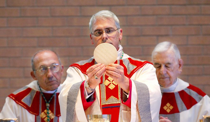 Archbishop Paul Coakley, center, is installed as the fourth archbishop of the Oklahoma City Archdiocese in a ceremony at St. John the Baptist Catholic Church, in Edmond, Okla., in this Feb. 11, 2011, file photo. (AP Photo/The Oklahoman, Jim Beckel, File)