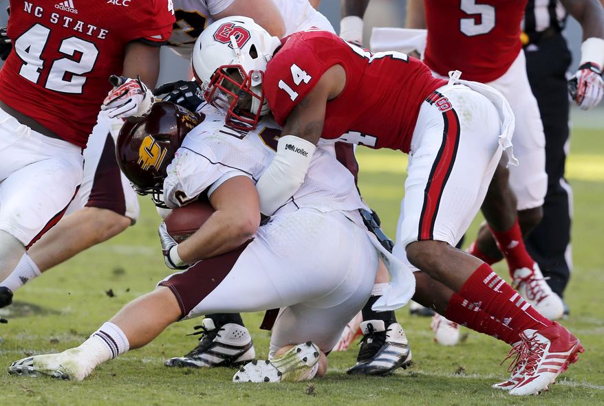 In this Sept. 28, 2013, photo, N.C. State NCAA college football safety Jarvis Byrd (14) tackles Central Michigan running back Saylor Lavallii (6) during the second half of a game against Central Michigan in Raleigh, N.C. North Carolina State safety Jarvis Byrd has suffered three serious knee injuries in his college career, including last year in the fifth game of the season. Now Byrd is a sixth-year senior is slowly working his way back in preseason camp with the hope of playing meaningful snaps.(AP Photo/The News & Observer, Ethan Hyman) MANDATORY CREDIT-ETHAN HYMAN, THE NEWS & OBSERVER