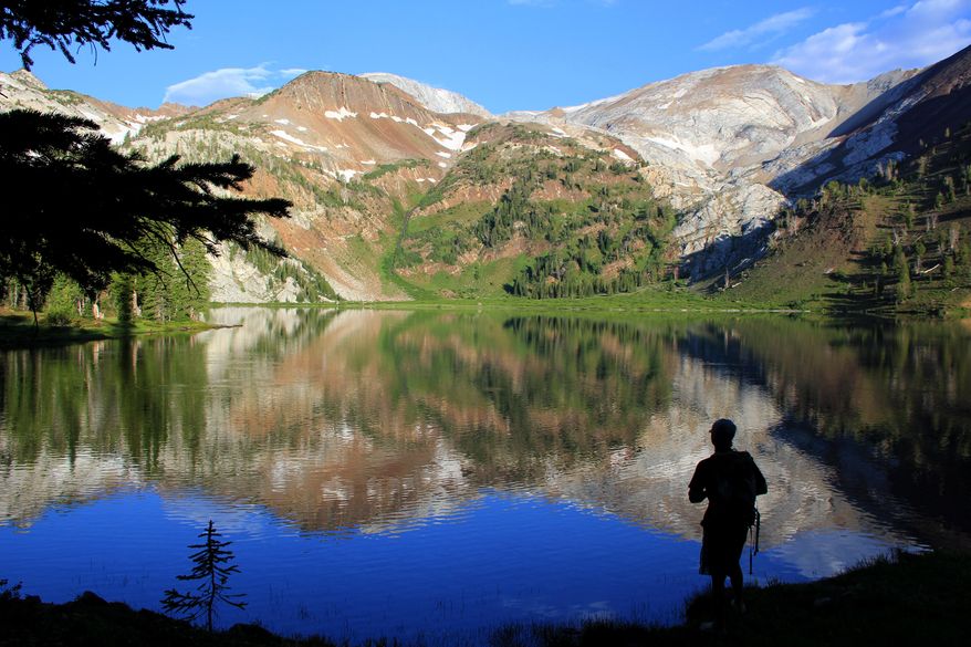 ADVANCE FOR THE WEEKEND OF AUG. 23-24 AND THEREAFTER - In a July 31, 2014 photo, Andy Gonerka stands in front of Ice Lake in the Eagle Cap Wilderness of northeastern Oregon's Wallowa Mountains. Home to 17 mountains that eclipse 9,000 feet and derived from the Nez Perce word for "land of running waters," the Wallowas of northeastern Oregon offer what many consider the state's best backpacking experience. (AP Photo/The Statesman Journal, Zach Urness)