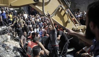A Palestinian man chants angry slogans as rescue workers search for victims under the rubble of a house destroyed in Israeli strikes in the Rafah refugee camp, Southern Gaza Strip, Thursday, Aug. 21, 2014. (AP Photo/Khalil Hamra)