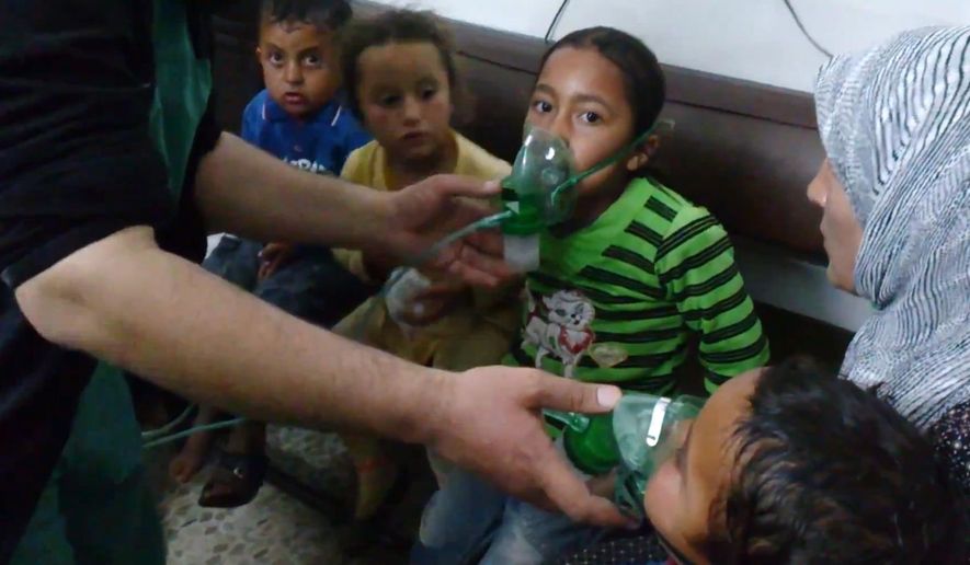 ** FILE ** In this image taken from video obtained from the Shaam News Network, posted on April 16, 2014, an anti-Bashar Assad activist group, which has been authenticated based on its contents and other AP reporting, children are seen receiving oxygen in Kfar Zeita, a rebel-held village in Hama province some 200 kilometers (125 miles) north of Damascus, Syria. An international human rights group says on the anniversary of the deadly chemical attack outside Damascus that “justice remains elusive” for the victims and their families. (AP Photo/Shaam News Network, File)