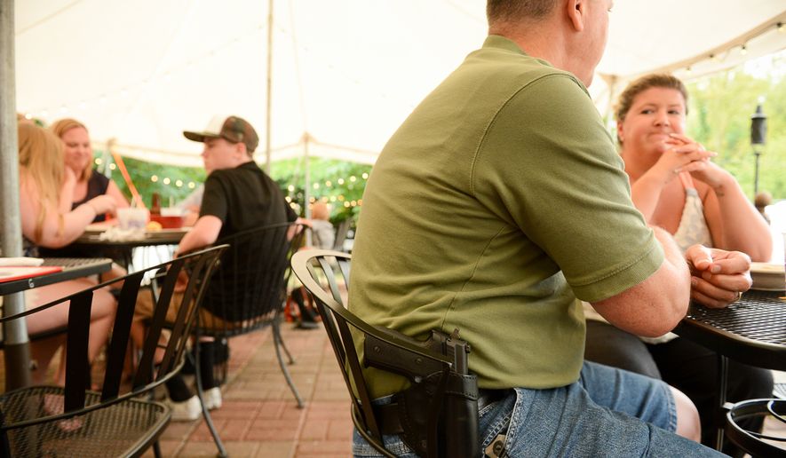 Don Amos and his wife Beth of Leesburg, Va. eat dinner with his gun at The Cajun Experience during Second Amendment Wednesdays where patrons are allowed to open carry their guns, Leesburg, Va., Wednesday, August 20, 2014. (Andrew Harnik/The Washington Times)