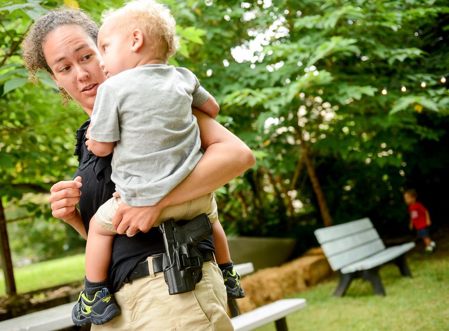 Naomi Leydig of Sterling, Va. and her son Jaden eat dinner with her gun at The Cajun Experience during Second Amendment Wednesdays where patrons are allowed to open carry their guns, Leesburg, Va., Wednesday, August 20, 2014. (Andrew Harnik/The Washington Times)