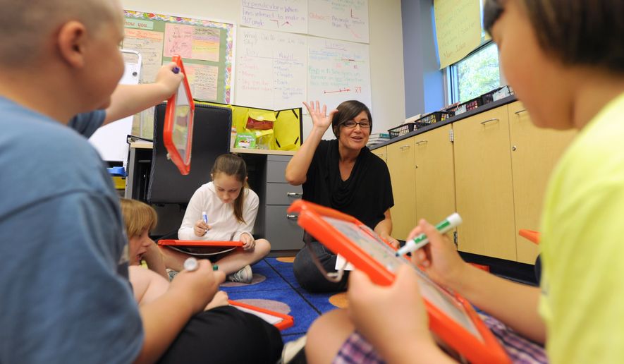 In this 2013 photo parent Amy Rowles helps out at Allen Frear Elementary school in Camden, Del., which won the state's Lt. Governor's award for parental involvement. (AP Photo/The News Journal, Gary Emeigh)