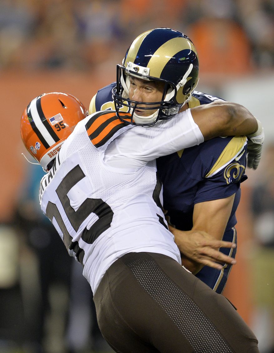 St. Louis Rams quarterback Sam Bradford is hit by Cleveland Browns defensive end Armonty Bryant (95) in the first quarter of a preseason NFL football game Saturday, Aug. 23, 2014, in Cleveland. Bradford left the game and was taken to the locker room after the play. (AP Photo/David Richard)