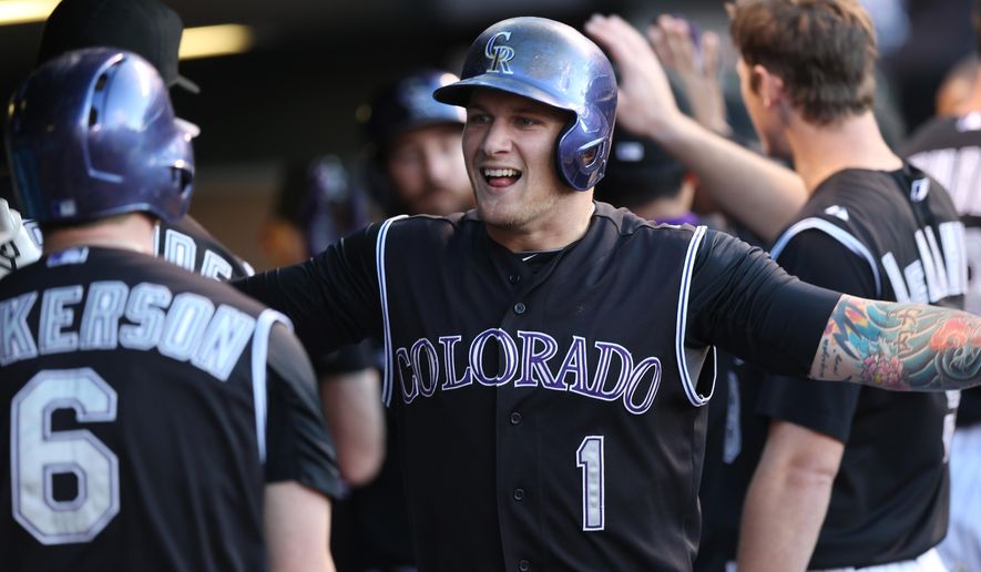 Colorado Rockies&#39; Corey Dickerson, left, congratulates Brandon Barnes after his two-run home run against the Miami Marlins in the third inning of a baseball game in Denver on Saturday, Aug. 23, 2014. (AP Photo/David Zalubowski)