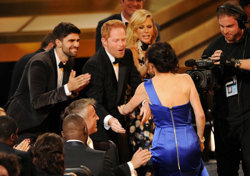 Gail Mancuso accepts the award for outstanding directing for a comedy series for her work on “Modern Family” at the 66th Annual Primetime Emmy Awards at the Nokia Theatre L.A. Live on Monday, Aug. 25, 2014, in Los Angeles. Looking on from left are Justin Mikita, Jesse Tyler Ferguson and Julie Bowen. (Photo by Chris Pizzello/Invision/AP)