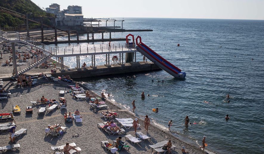 Tourists rest on the Black Sea beach in Yalta, Crimea. Last year the peninsula saw 5.9 million tourists. This summer only about 300,000 visited. (Associated Press)