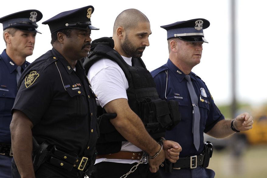 FILE - In this Aug. 26, 2010 file photo, Elias Abuelazam is escorted by authorities after arriving on a flight in Flint, Mich. Abuelazam, serving a life sentence for murder in a series of stabbings in the Flint area is suing to be deported to Israel, his home country. Elias Abuelazam says he committed attempted murder there in 2009 and is willing to stand trial and be sent to prison. His lawsuit against the federal government has been transferred to Washington from a federal court in Grand Rapids. (AP Photo/Paul Sancya)